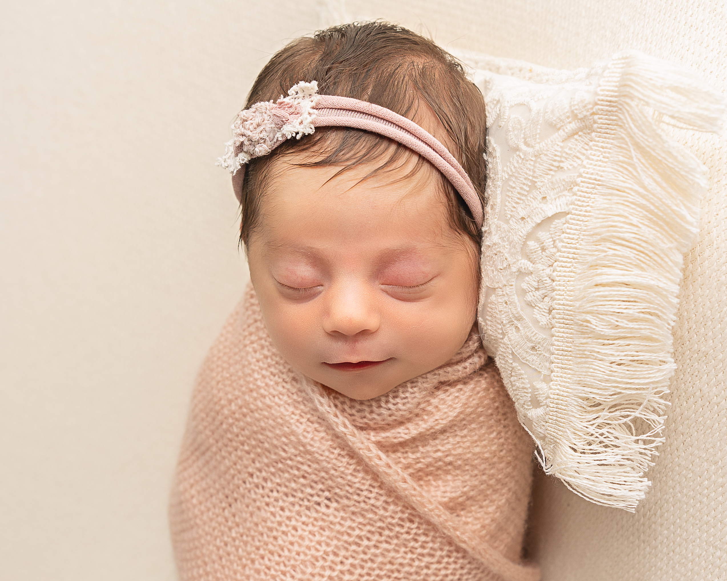 Baby girl wrapped in a neutral swaddle
