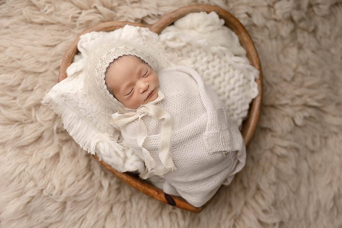 newborn baby wrapped in white laying in a heart Doula Love Portland