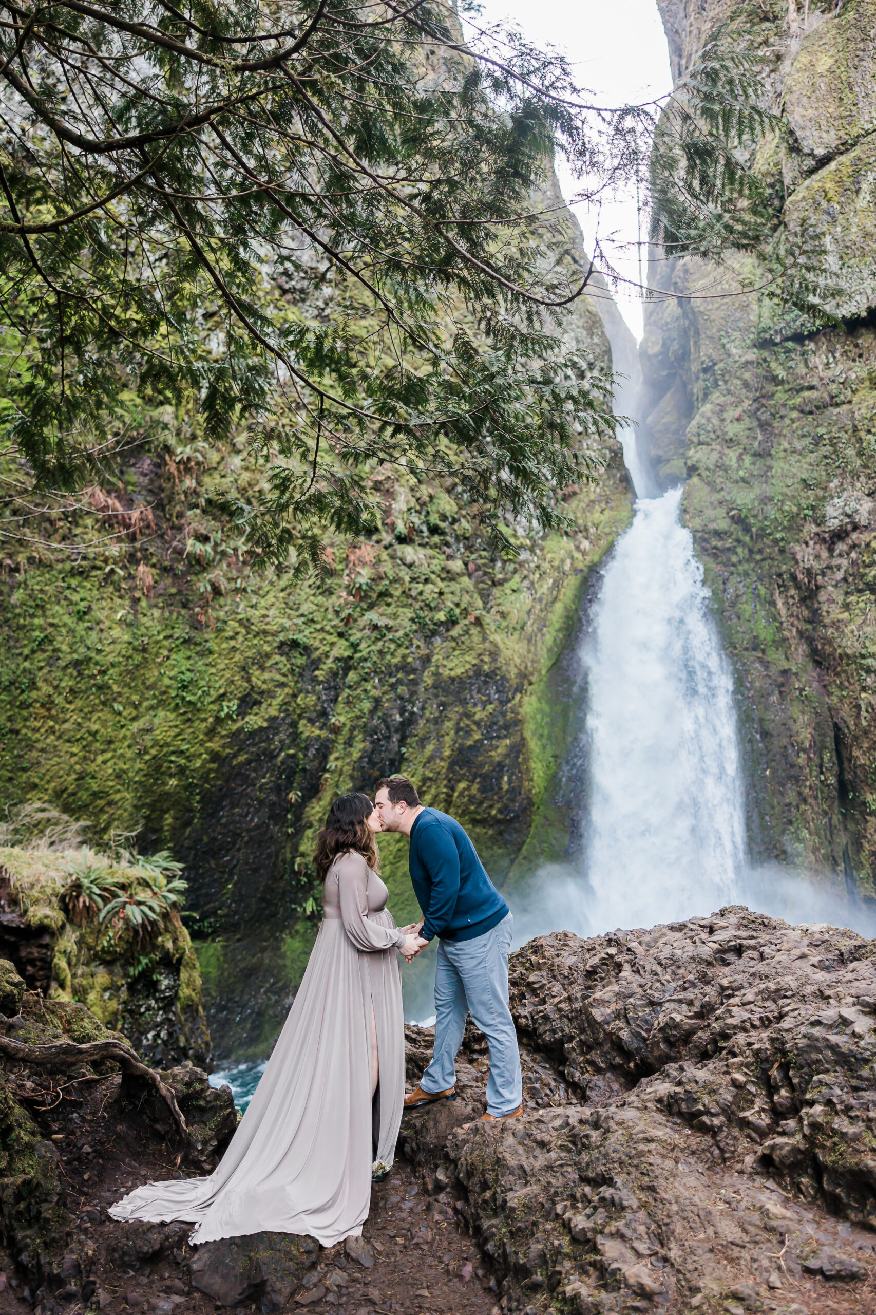 pregnant woman and man kissing at a waterfall portland baby shower venues
