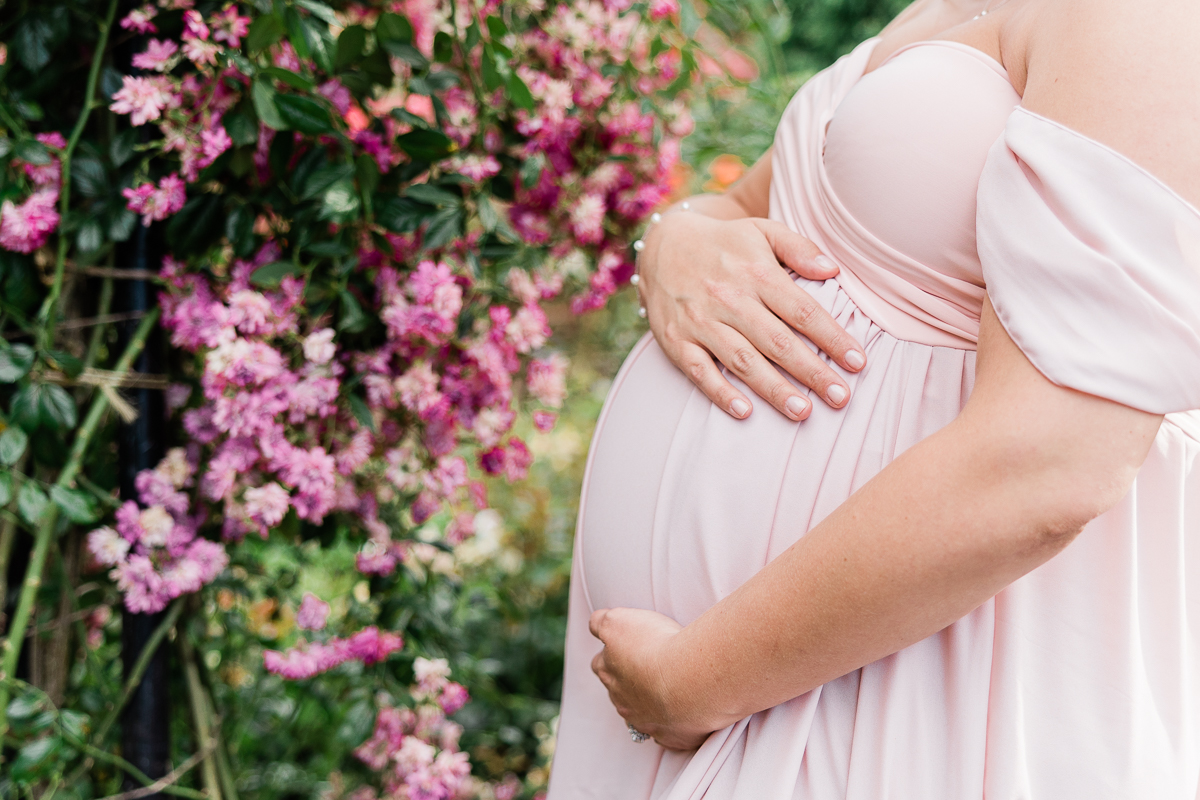 mom to be holding her bump in a garden Unfurling birth
