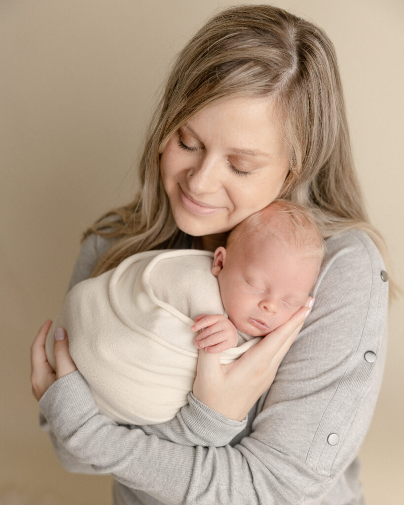 new mom cuddling her new baby in neutral clothing Brave Birth Doulas