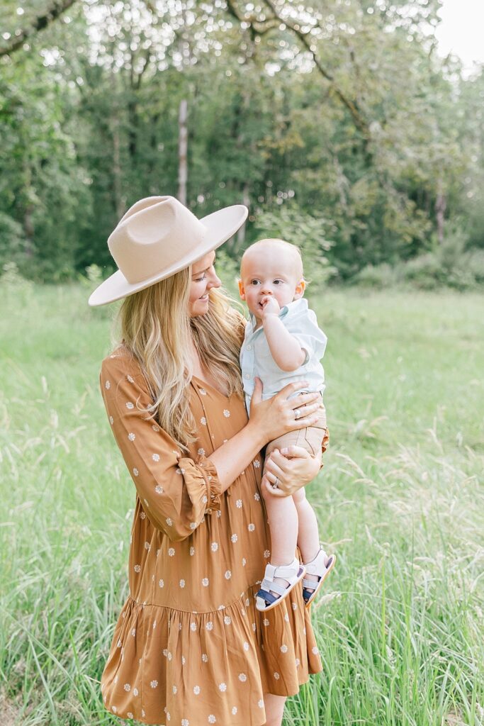 mom in brown dress and hat holding her young son