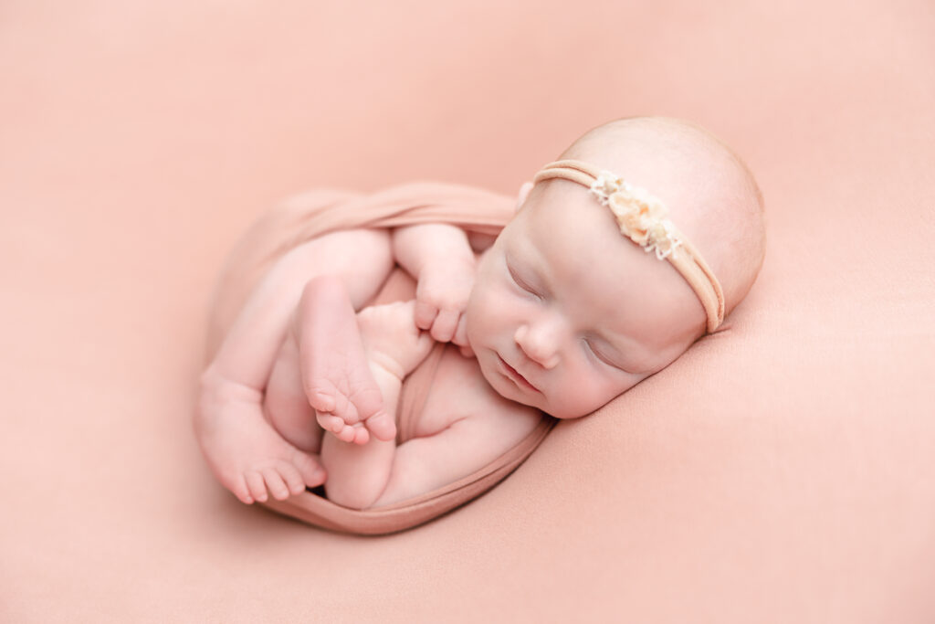 newborn baby girl wrapped in a neutral blanket sleeping Portland Natural Birth-