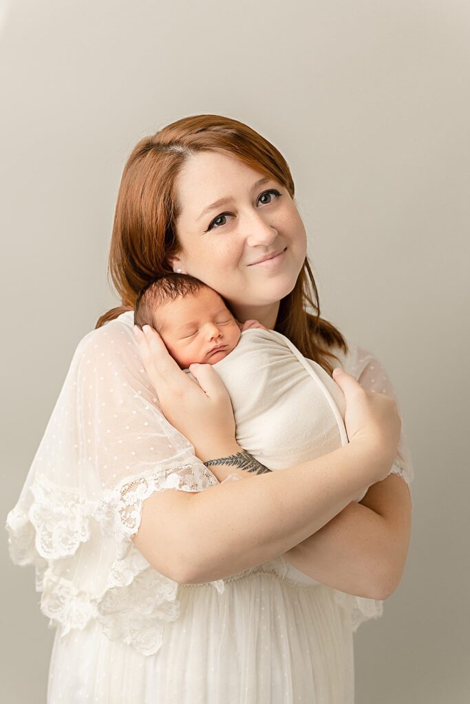 new mom in white holding her newborn baby in her arms Canyon Medical Center Portland