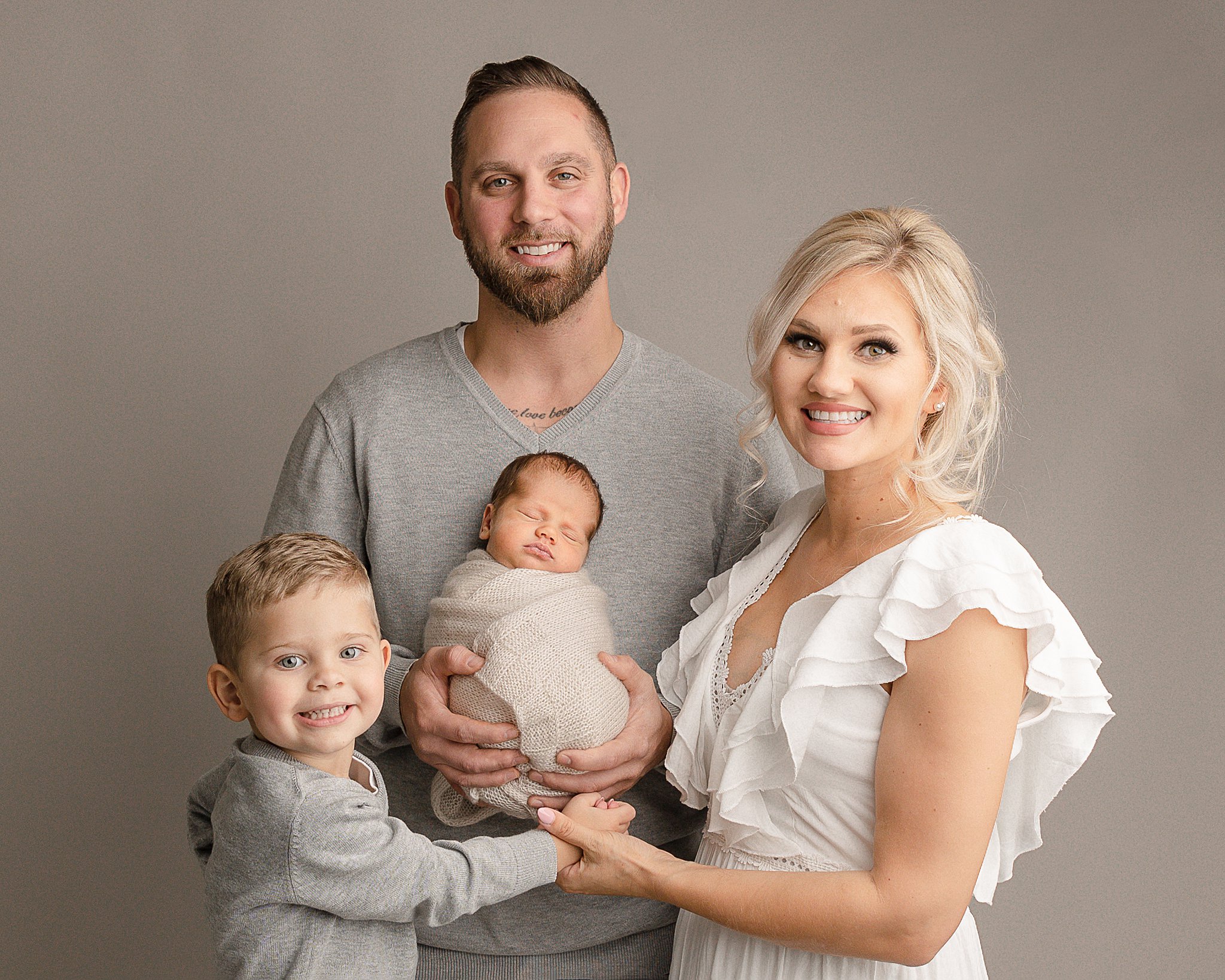 new family of four smiling in a studio
